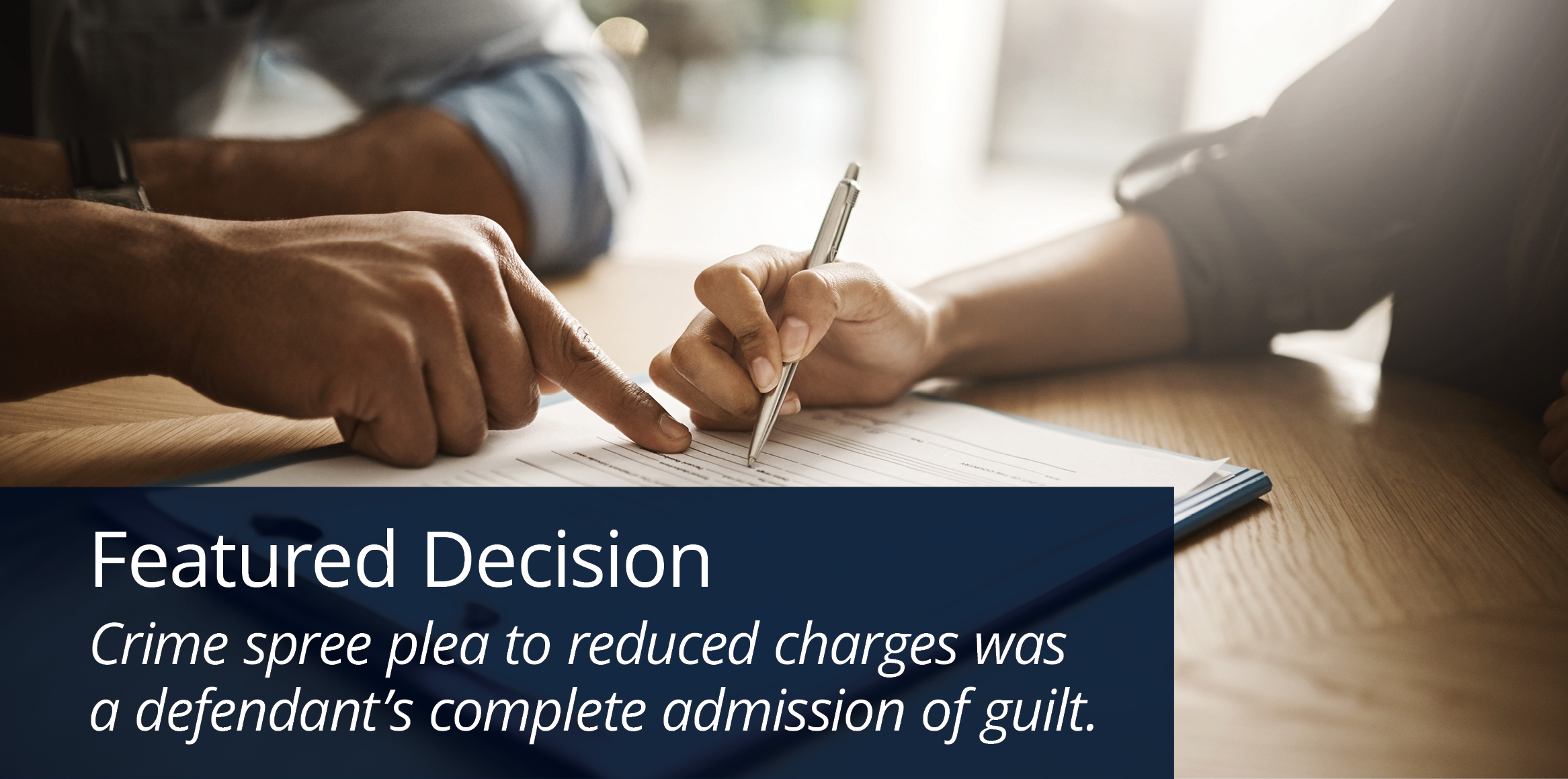 A person's hand holding a sleek silver pen, poised to sign a formal document resting on a blue clipboard.